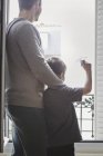 Boy launching paper plane with father from window — Stock Photo