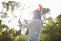Retrato de mujer madura en bosques apuntando arco y flecha - foto de stock