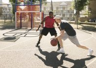 Dois jogadores de basquete do sexo masculino praticando na quadra de basquete — Fotografia de Stock