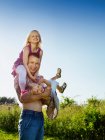 Отец играет с дочерьми на открытом воздухе — стоковое фото