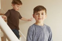 Retrato de niño y hermano pequeño en las escaleras - foto de stock