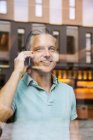 Бизнесмены делают телефонный звонок, просматривают через окно — стоковое фото