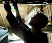 Mechaniker unter Auto auf der Suche nach Problem — Stockfoto