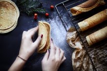 Imagen recortada de Mujer preparando galletas krumkake - foto de stock