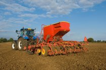 Trator de condução do agricultor e milho semente de perfuração no campo — Fotografia de Stock