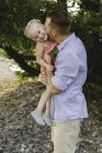 Metà uomo adulto che porta e bacia la figlia sulla guancia al lago Ontario, Oshawa, Canada — Foto stock