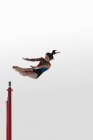 Молодая гимнастка выступает на неровных брусьях — стоковое фото