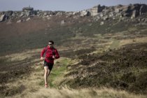 Männlicher Läufer, der in der Nähe von Stanage Edge, Peak District, Derbyshire, Großbritannien läuft — Stockfoto