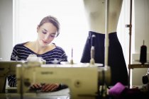 Seamstress working at sewing machine — Stock Photo