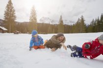Giovane uomo e figli che lottano con la palla di neve in inverno, Elmau, Baviera, Germania — Foto stock