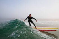 Uomo in costume da bagno surf un'onda oceanica, boobys bay, cornwall, Inghilterra — Foto stock