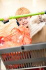 Boy pushing cart in grocery store — Stock Photo
