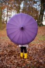Abgeschnittenes Bild eines Mädchens, das mit Regenschirm im Park spielt — Stockfoto