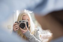 Adolescente menina fotografar amigo com câmera — Fotografia de Stock