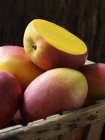 Цельные и нарезанные свежие органические манго — стоковое фото