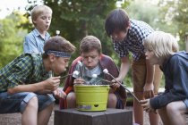 Group of little boys toasting marshmallows over bucket barbecue — Stock Photo