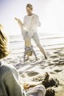 Padre ayudando hijo con handstand en playa - foto de stock