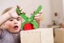 Menina brincando com alicate de brinquedo — Fotografia de Stock