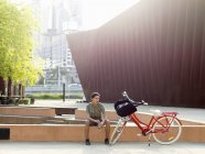 Молодой человек отдыхает рядом с велосипедом, Саутбанк, Мельбурн, Австралия — стоковое фото