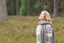 Взрослая женщина в свитере с закрытыми глазами — стоковое фото