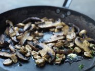 Friture de champignons au beurre dans une poêle, gros plan — Photo de stock