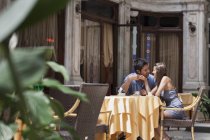 Молодая пара, сидящая снаружи кафе, Турин, Пьемонт, Италия — стоковое фото