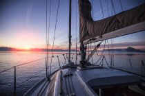 Convés do barco ao pôr-do-sol com montanhas no horizonte — Fotografia de Stock
