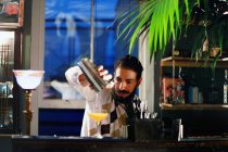 Мужчина-бармен, подающий коктейль в баре — стоковое фото