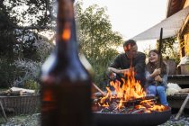 Father and daughter in garden with fire pit — Stock Photo