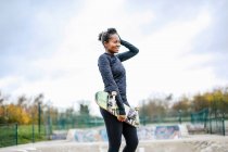 Портрет молодої жінки скейтбордистки в парку скейтбордів — стокове фото