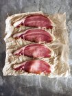 Bacon slices on brown paper, top view — Stock Photo