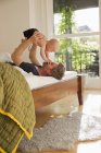 Père jouant avec bébé fille sur le lit — Photo de stock