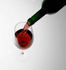 Verser du vin rouge dans un verre — Photo de stock