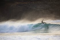Silhouetted young man surf wave al tramonto, Fuerteventura, Spagna — Foto stock