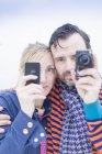 Paar fotografiert mit Smartphone und Kamera im Freien — Stockfoto