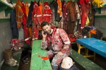 Homem pintor navio sentado no galpão falando no smartphone — Fotografia de Stock