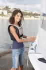 Porträt einer fröhlichen jungen Frau beim Vorbereiten eines Segelbootes — Stockfoto