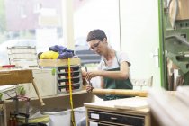Mujer en taller haciendo alphorn - foto de stock