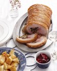 Stuffed roast pork joint with crispy crackling and roasted potatoes — Stock Photo
