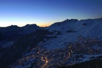 Nachts beleuchtete Stadt unter dem Gebirge — Stockfoto