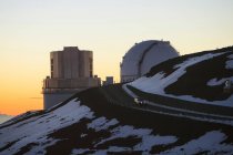 Observatorio en la ladera nevada durante la puesta del sol - foto de stock