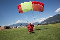 Skydiver aterrissando paraquedas em campo. Direção e desaceleração de seu dossel puxando interruptores de pausa, Locarno, Tessin, Suíça — Fotografia de Stock