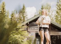 Frau im Garten trägt Coton de tulear Hund, orivesi, Finnland — Stockfoto