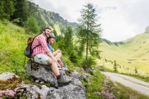 Casal jovem sentado em rochas, Tirol, Áustria — Fotografia de Stock