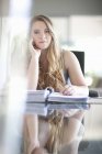 Junge Geschäftsfrau sieht gelangweilt von Papierkram aus — Stockfoto