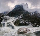 Motion blurred water flowing down misty rocks — Stock Photo