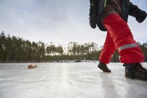Обрізаний знімок хлопчика, що йде на замерзлому озері — стокове фото