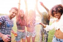 Group of friends at festival, covered in colourful powder paint — Stock Photo