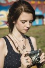 Молодая женщина фотографирует на камеру SLR на ярмарке — стоковое фото