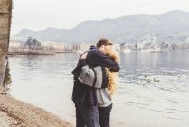 Giovani coppie che si abbracciano sul lungolago, Lago di Como, Italia — Foto stock